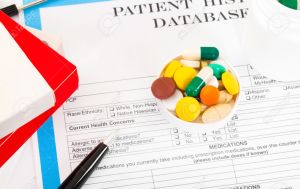 Doctor workplace. Pills, tablets, pen on patient history database